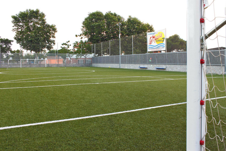 Fußballplatz im Ferienpark Camping La Masia in Katalonien, Spanien, mit grünem Rasen und Tor.