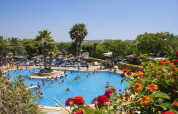 Piscina affollata di turisti e palme al campeggio La Masia, parco vacanze in Catalogna, Spagna.