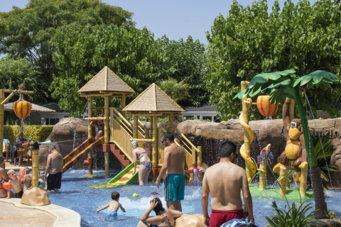 Bambini e adulti si divertono nell'area giochi d'acqua al Camping La Masia in Catalogna, Spagna.