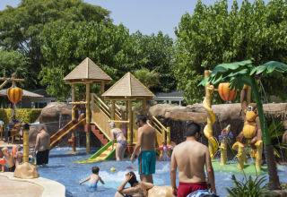 Bambini e adulti si divertono nell'area giochi d'acqua al Camping La Masia in Catalogna, Spagna.
