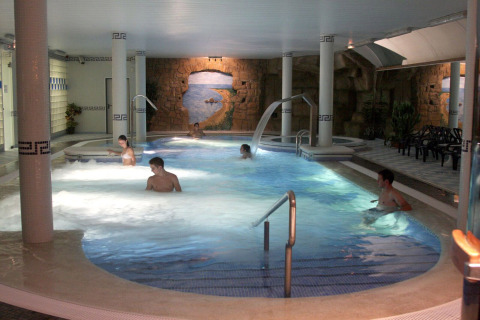 Zona de piscina cubierta en Camping La Masia, Cataluña, España, con huéspedes disfrutando del agua.
