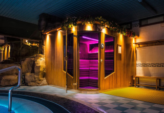 Zona sauna e piscina interna con luci colorate al Camping La Masia, parco vacanze in Catalogna, Spagna.
