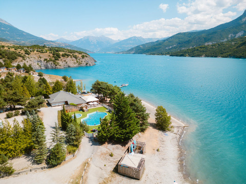Vista aérea de Camping La Presqu’île junto al lago azul y montañas en Provenza-Alpes-Costa Azul, Francia.
