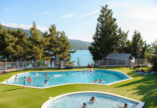 Villaggio turistico con piscine e vista lago al Camping La Presqu’île in Provenza-Alpi-Costa Azzurra, Francia.