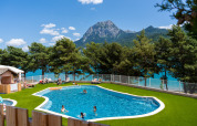Outdoor swimming pool with a view of a lake and mountains at Camping La Presqu’île in Provence-Alpes-Côte d’Azur, France.