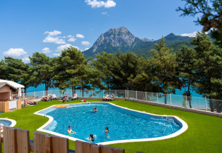 Außenpool mit Blick auf einen See und Berge im Ferienpark Camping La Presqu’île, Provence-Alpes-Côte d’Azur.
