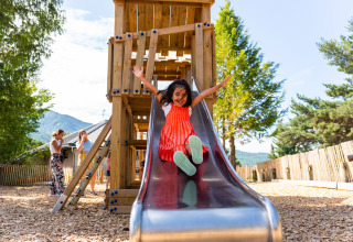 Una bambina felice scende dallo scivolo al parco giochi del Camping La Presqu’île in Provenza, Francia.