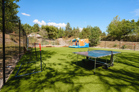 Campo deportivo con mesa de ping pong, porterías y castillo hinchable en Camping La Presqu’île, Provenza-Alpes-Costa Azul.