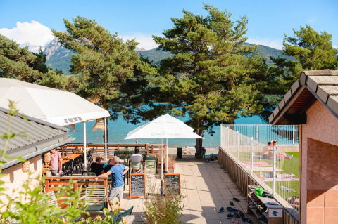 Holiday park with outdoor terrace and lake view at Camping La Presqu’île in Provence-Alpes-Côte d’Azur, France.