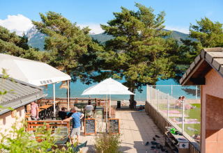 Feriepark med udendørs café og udsigt til søen ved Camping La Presqu’île i Provence-Alpes-Côte d’Azur, Frankrig.