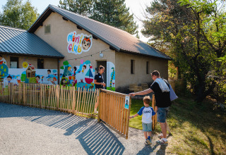 Vader en zoon gaan het miniclubje binnen bij Camping La Presqu’île in Provence-Alpes-Côte d’Azur, Frankrijk.