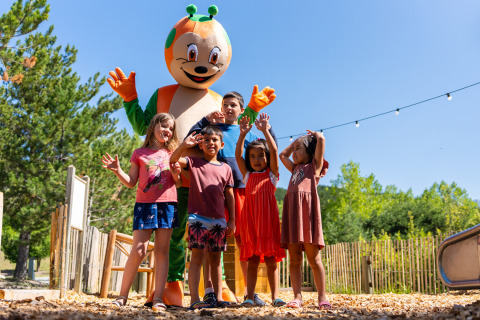 Bambini posano con una mascotte colorata al Camping La Presqu’île in Provenza-Alpi-Costa Azzurra, Francia.