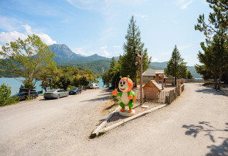 Zicht op Camping La Presqu’île in Provence-Alpes-Côte d’Azur met speeltuin, bergen en een meer.