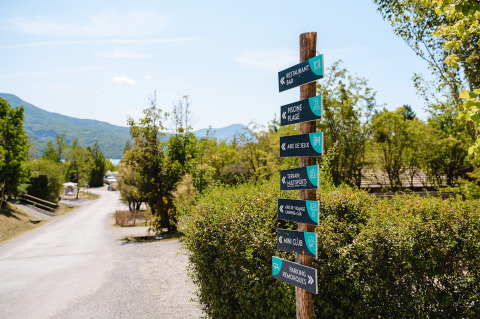 Signpost at Camping La Presqu’île holiday park in Provence-Alpes-Côte d’Azur, France, with nature views.