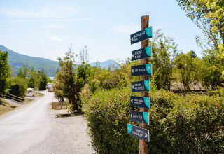 Signpost at Camping La Presqu’île holiday park in Provence-Alpes-Côte d’Azur, France, with nature views.