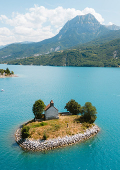 Pequeña isla con casa rodeada de agua azul en Camping La Presqu’île, Provence-Alpes-Côte d’Azur, Francia.