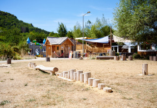 Legeplads med træhytter og legeredskaber på Camping La Roche d’Ully i Bourgogne-Franche-Comté, Frankrig