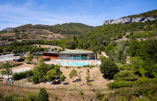 Aerial view of Camping La Roche d’Ully with a swimming pool, guests, and green hills in Bourgogne-Franche-Comté.