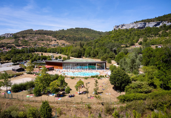 Aerial view of Camping La Roche d’Ully with a swimming pool, guests, and green hills in Bourgogne-Franche-Comté.