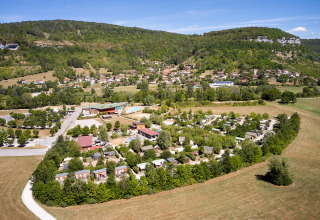 Feriepark Camping La Roche d’Ully i Bourgogne-Franche-Comté, Frankrig, omgivet af bakker og grøn natur.