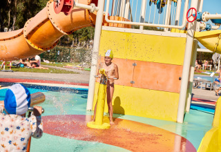 Kinder spielen mit Wasserkanonen auf einem Wasserspielplatz im Camping Laguna Blu, Sardinien, Italien.
