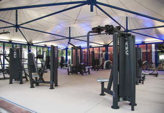 Moderne udendørs fitnesscenter på Camping Laguna Blu i Sardinien, Italien, med flere træningsmaskiner.