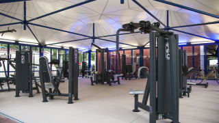 Modern outdoor gym at Camping Laguna Blu in Sardinia, Italy, featuring various exercise machines.