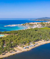Vista aérea de Camping Laguna Blu, parque vacacional en Cerdeña, Italia, con mar y frondosos árboles.