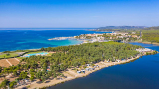 Aerial view of Camping Laguna Blu, a holiday park in Sardinia, Italy, featuring coastline, sea and trees.