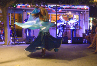 Une danseuse orientale se produit devant un public et des musiciens au Camping Le Canigou, Occitanie, France.