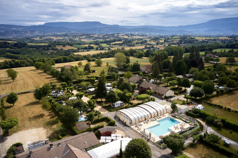 Vista aérea de Camping Le Coin Tranquille en Auvernia-Ródano-Alpes, Francia, con piscina y campos verdes alrededor.