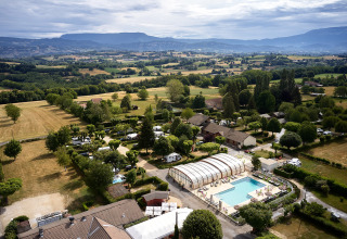 Luftaufnahme vom Camping Le Coin Tranquille in Auvergne-Rhône-Alpes, Frankreich, mit Pool und weitem Talblick.