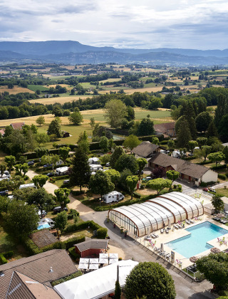 Luchtfoto van Camping Le Coin Tranquille in Auvergne-Rhône-Alpes, Frankrijk, met zwembad en groene velden.