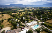 Luftaufnahme vom Camping Le Coin Tranquille in Auvergne-Rhône-Alpes, Frankreich, mit Pool und weitem Talblick.