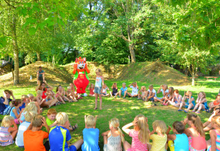 Kinderen spelen in een kring buiten bij Camping Le Coin Tranquille in Auvergne-Rhône-Alpes, Frankrijk.