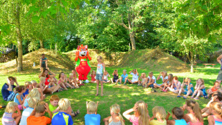 Niños jugando en círculo al aire libre en Camping Le Coin Tranquille en Auvernia-Ródano-Alpes, Francia.