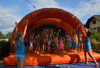 Kinderen spelen op een springkussen bij Camping Le Coin Tranquille in Auvergne-Rhône-Alpes, Frankrijk.