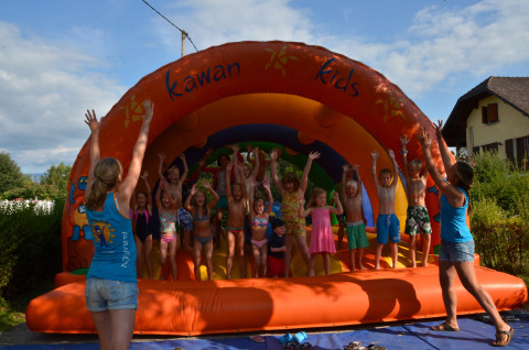 Kinderen spelen op een springkussen bij Camping Le Coin Tranquille in Auvergne-Rhône-Alpes, Frankrijk.