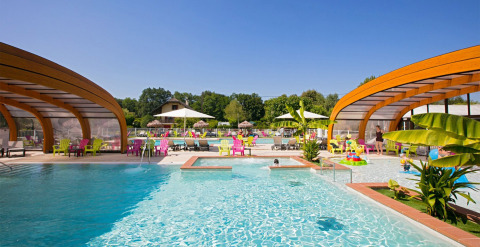 Piscina al aire libre en Camping Le Coin Tranquille en Auvergne-Rhône-Alpes, Francia, con sillas coloridas y sombrillas.