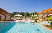 Piscine extérieure au Camping Le Coin Tranquille en Auvergne-Rhône-Alpes, France, avec chaises colorées et parasols.
