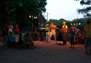 Buitenoptreden op Camping Le Pech Charmant in Nouvelle-Aquitaine, Frankrijk, met band en toeschouwers.