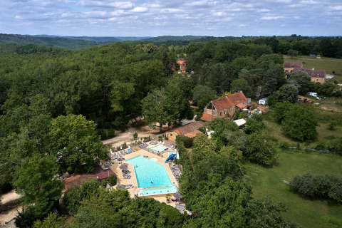 Vista aérea de Camping Le Pech Charmant, parque vacacional con piscina en Nouvelle-Aquitaine, Francia.