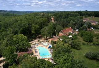 Luchtfoto van Camping Le Pech Charmant, vakantiepark met zwembad in een groene omgeving, Nouvelle-Aquitaine.
