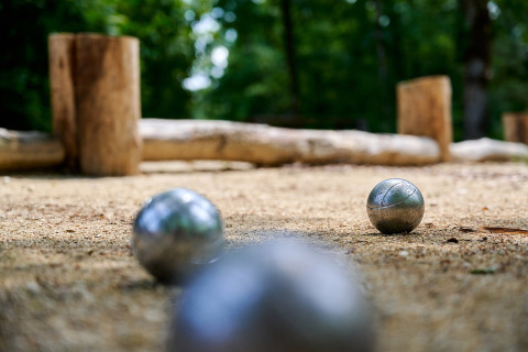 Bolas de petanca en una cancha de arena en Camping Le Pech Charmant, Nouvelle-Aquitaine, Francia.