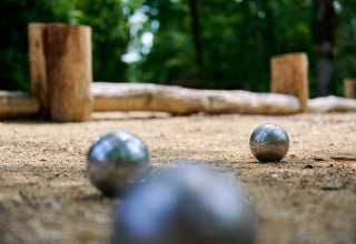 Petanqueballen op een zandveld bij Camping Le Pech Charmant in Nouvelle-Aquitaine, Frankrijk.