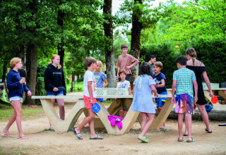 Kinderen spelen tafeltennis en verzamelen zich buiten op Camping Le Pech Charmant, Nouvelle-Aquitaine.