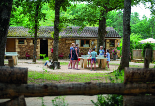 Families genieten van een potje tafeltennis in de natuur op Camping Le Pech Charmant in Frankrijk.