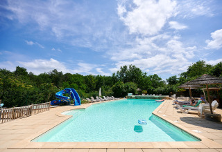Buitenzwembad met ligbedden, glijbaan en parasols op Camping Le Pech Charmant in Nouvelle-Aquitaine.