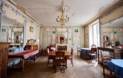 Elegant, klassisk indrettet salon med lysekroner, spejle, antikke møbler og dekorerede vægge på Le Petit Trianon.