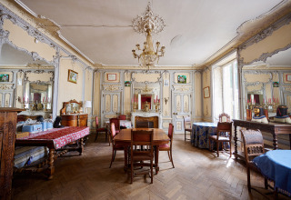 Elegant, klassisk indrettet salon med lysekroner, spejle, antikke møbler og dekorerede vægge på Le Petit Trianon.